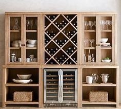 a wooden cabinet with wine bottles and glasses