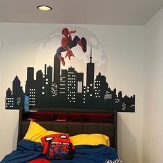 a bedroom with a spiderman mural on the wall