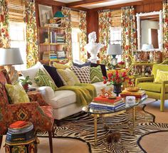 a living room filled with lots of furniture and colorful pillows on top of it's couches