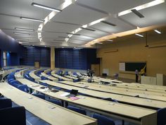 an empty lecture hall with rows of desks