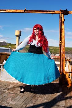 a woman with red hair wearing a blue skirt