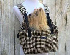 a small dog in a black and white checkered bag on a mannequin