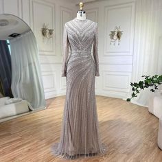 Step into sophistication with these 2024 Muslim silver nude beaded sparkle elegant luxury mermaid evening dresses, tailored for an enchanting party affair. Designed with the utmost elegance, these dresses feature intricate beadwork that sparkles and shimmers, adding a touch of glamour to your ensemble. The mermaid silhouette gracefully accentuates your curves, ensuring a flattering and feminine silhouette that exudes confidence. Perfect for Muslim women, these dresses offer a blend of modesty and style, allowing you to feel comfortable and elegant at any event. Whether it's a formal party or a special occasion, these gowns are sure to make a statement and leave a lasting impression. Elements Of Drama, Silver Mermaid, Mermaid Evening Dresses, Mermaid Silhouette, Cape Dress, Luxury Dress, Women Party, Ladies Party, British Indian