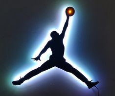 a person jumping up in the air with a basketball