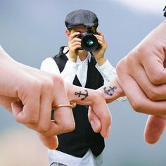 three people holding their hands with tattoos on them and pointing fingers at the other hand