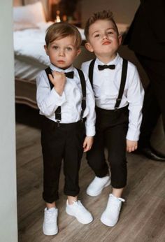 two young boys dressed in black and white tuxedos