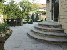 a patio with stone steps and seating area