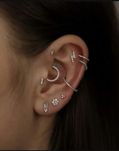 a woman wearing three different ear piercings