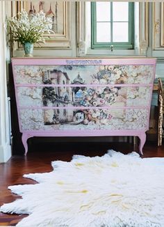 an old dresser is painted pink and has pictures on it