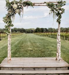 an outdoor ceremony setup with flowers and greenery