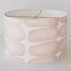 a pink and white lamp shade with gold trim on the bottom that has an animal print pattern