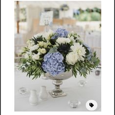 a vase filled with blue and white flowers on top of a table