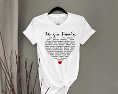 a white t - shirt with words written on it and a red heart hanging from a hanger