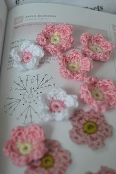 an open book with crocheted flowers on it