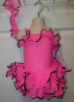 Brand new dancecostume, the leotard front is a 3mm faux sequin fabrication in Hot pink, the ruffles are nylon organdy trimmed in black sequin. The back is matte spandex to ensure a good fit. THe trim at the front has to be pinned on the back but there is enough extra that if you wanted you could pin it up and over one of the shoulders for a more Latina look. Otherwise, you could cut the excess off and use it in the hair GC54 tckldpnk We ship out same day Monday through Friday (unless you buy aft Pink Summer Party Leotard, Pink Fitted Leotard For Swimming, Pink Fitted Dance Leotard, Fitted Pink Leotard For Swimming, Fitted Nylon Leotard For Party, Pink Stretch Leotard For Dance, Pink Dance Costumes, Black Sequins, Dance Costumes