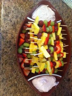 fruit skewers are arranged on a platter