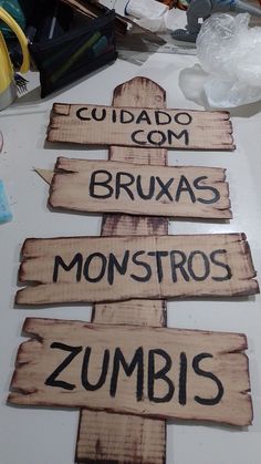 several wooden signs that say cuidado com bruxas monstros zumbis