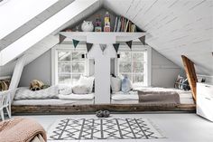 an attic bedroom with two twin beds in the middle and a rug on the floor