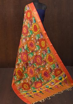 This enchanting dupatta features a hand-painted floral theme, showcasing authentic Pen Kalamkari artistry on luxurious Mangalagiri silk cotton in a muddy brown hue. The intricate floral motifs burst to life against the earthy backdrop, creating a harmonious and captivating visual narrative that celebrates the beauty of nature. The soft, breathable fabric drapes elegantly, providing both comfort and sophistication for any occasion. Adorned with a shimmering Nizam zari border, this dupatta adds a touch of opulence, making it perfect for festive celebrations or special gatherings. A true reflection of traditional craftsmanship, this piece seamlessly blends artistry with contemporary style, making it a timeless addition to your collection. *Note: This is an authentic Pen kalamkari dupatta made Kalamkari Dupatta, Simple Casual Outfits, Visual Narrative, Floral Theme, Draped Fabric, Floral Motifs, Indian Design, Ambient Lighting, Floral Painting