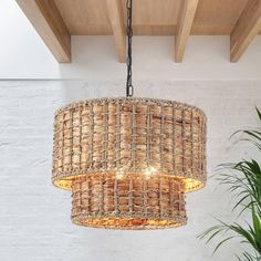 a chandelier hanging from the ceiling in a room with white brick walls and wooden beams