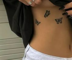 a woman's stomach with butterflies tattooed on her side and the bottom part of her body