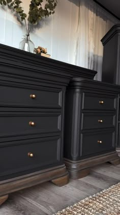 a black dresser sitting on top of a wooden floor