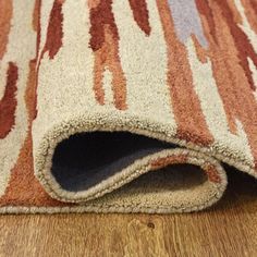 a close up of a rug on the ground with wood flooring in the background