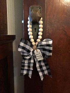 a black and white bow on a door handle with a name tag attached to it