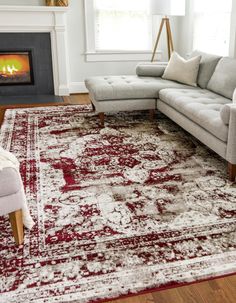 a living room area with a couch, chair and rug on the floor in front of a fire place