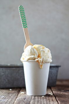 a cup filled with ice cream on top of a wooden table