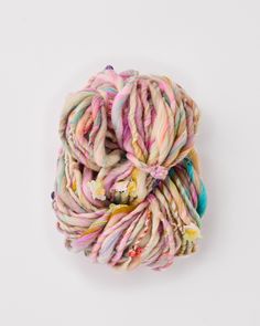 a skein of multicolored yarn on a white surface