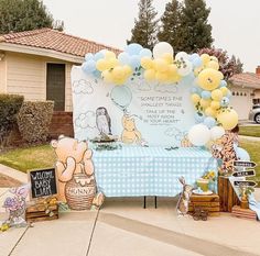 winnie the pooh themed birthday party with balloons, decorations and table cloths on it