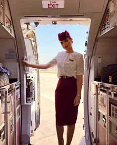 a woman standing in the doorway of an airplane