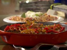 a pan filled with food sitting on top of a counter next to other plates and utensils