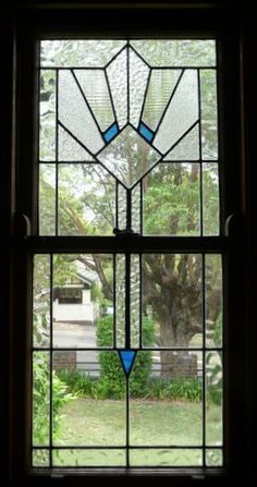 an image of a stained glass window that is open and looking out at the yard