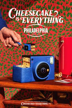 a blue camera sitting on top of a wooden table next to a red box with crackers in it