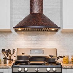 a stove top oven sitting inside of a kitchen next to a counter with pots and pans on it