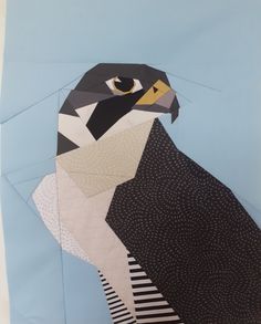 a bird made out of paper on top of a piece of blue paper with black and white stripes