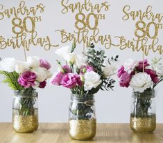 three mason jars filled with flowers on top of a table