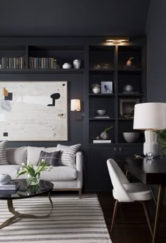 a living room filled with furniture and bookshelves next to a lamp on a table