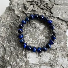 Inspired by natural gemstones and crystals, our Power Beads bracelets feature a range of smooth, vividly colored stones, representing the union of symbolism and style. Masculine and high energy, each gemstone in this meaningful bracelet is individually cut and polished from natural stones and meticulously handcrafted in USA. Adjusts over the wrist for easy transitions and offers versatile styling options for comfortable day and night wear. Blue Tiger's Eye Gemstones, 10mm Trident Symbol with CZ Trident Symbol, Diamond Symbol, Mixed Metal Bracelets, Gemstones And Crystals, Blue Tigers, Beads Bracelets, Blue Tigers Eye, Colored Stones, Tigers Eye Gemstone