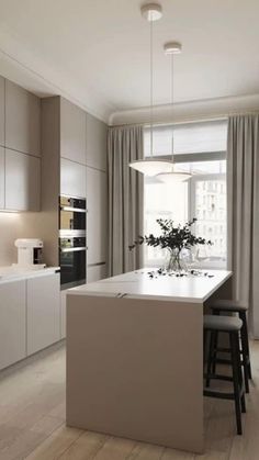 a modern kitchen with an island counter and stools next to the window in front of it