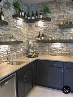 a kitchen with stone walls and stainless steel appliances in the corner, along with open shelving