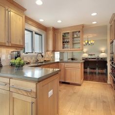 a large kitchen with wooden cabinets and stainless steel appliances in it's center island