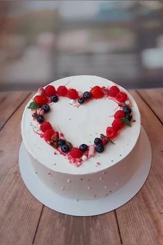 a heart shaped cake sitting on top of a wooden table