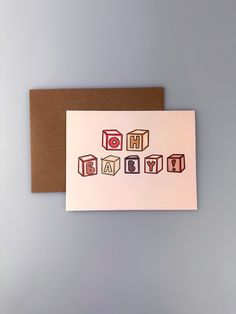 a greeting card with the word happy birthday written in colorful blocks on top of it