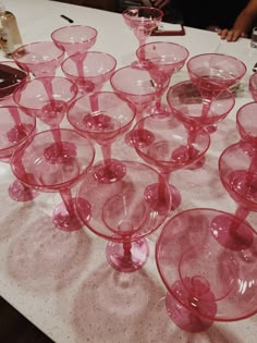 many pink wine glasses sitting on top of a table