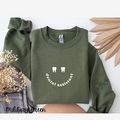 Cute sweatshirt for a Dental Assistant:) LINK FOR T SHIRT BELOW:) https://www.etsy.com/listing/1772867928/dental-assistant-shirt-comfort-colors *Before ordering, see ALL photos for details such as SIZE & FIT.  *If you want an oversized look and feel, order 1 to 2 sizes up * Sweatshirt is Gildan -CARE- Wash in cold water, Tumble dry low heat * Design/text is direct to garment printing ( no vinyl, no peeling or cracking )   --ABOUT-- Sweatshirt is Gildan, A heavy blend crewneck sweatshirt, pure comfort. These garments are made from polyester and cotton. This combination helps designs come out looking fresh and beautiful. The collar is ribbed knit, so it retains its shape even after washing. There are no itchy side seams on these sweaters.  - Made with a medium-heavy fabric blend of 50% cotto Dental Assistant Scrubs, Dental Assistant Shirts, Dental Shirts, Pediatric Dental, Dental Assistant, Cute Sweatshirts, Valentines Shirt, Christmas Sweatshirts, Cut And Style