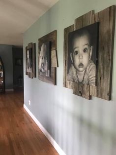 a hallway with pictures on the wall and wood flooring in front of it, including a baby's head