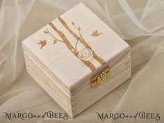 a small wooden box with an owl on it's lid sitting on a white cloth